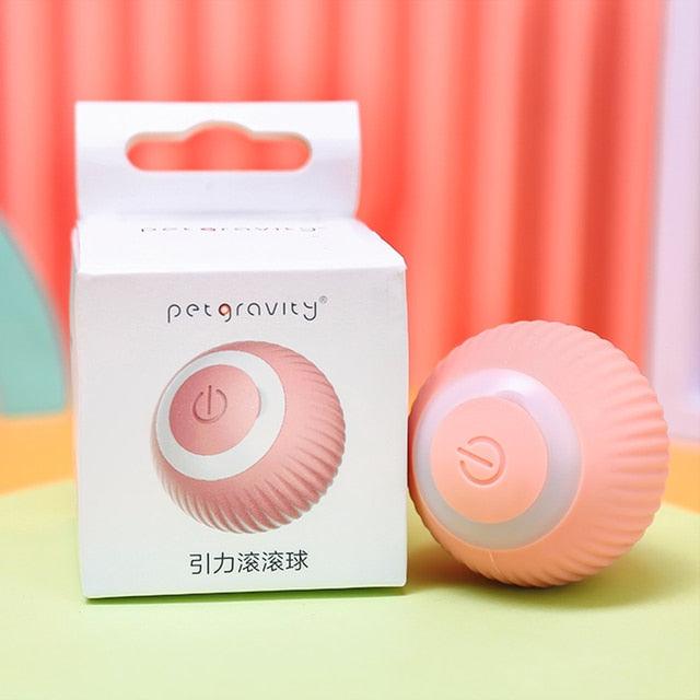 Stevvex pink rechargeable smart cat rolling ball toy with center power button beside its box on Tampa Home & Garden Store