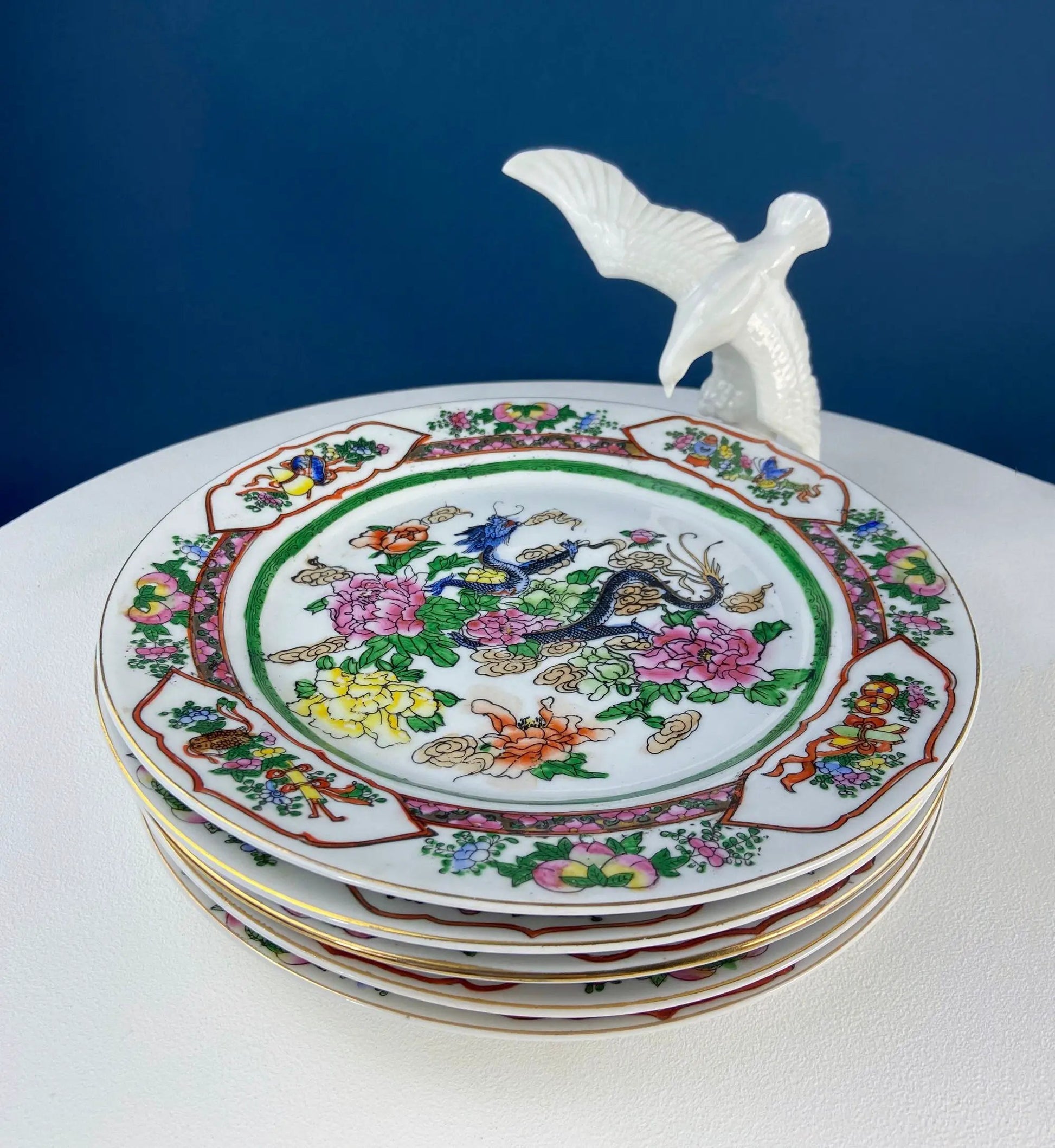 Five large porcelain Asian plates with dragon and peony motifs, stacked on Tampa Home & Garden Store