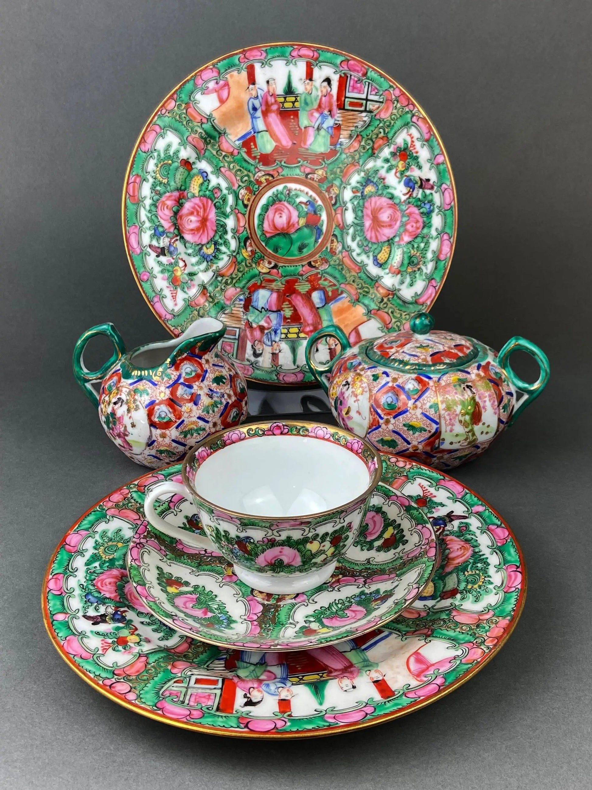 Five large Asian porcelain plates with dragons and peonies in green and pink, gold rims on Tampa Home & Garden Store