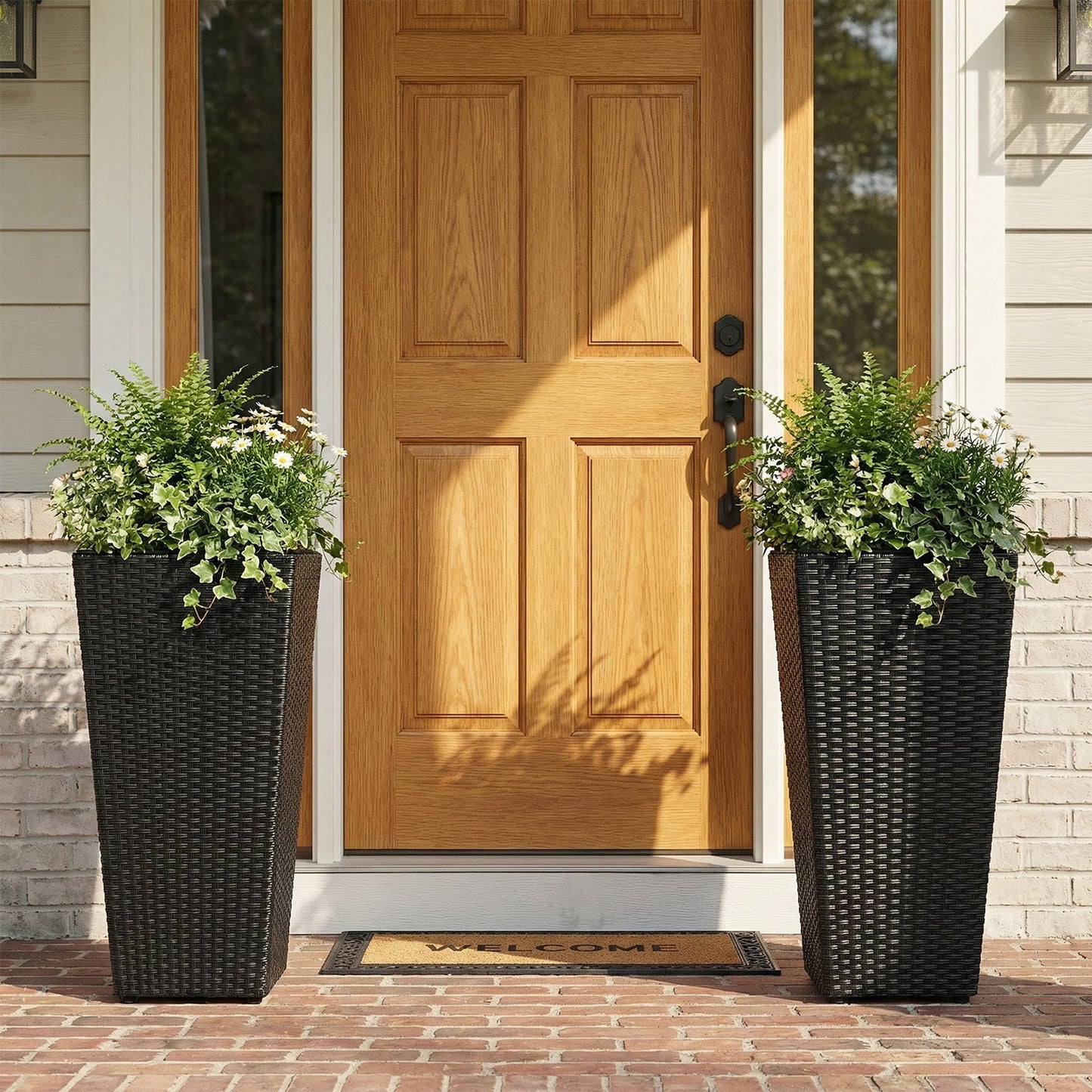 Set of 2 black rattan tall plant pots with detachable liners, greenery and daisies by the door on Tampa Home & Garden Store