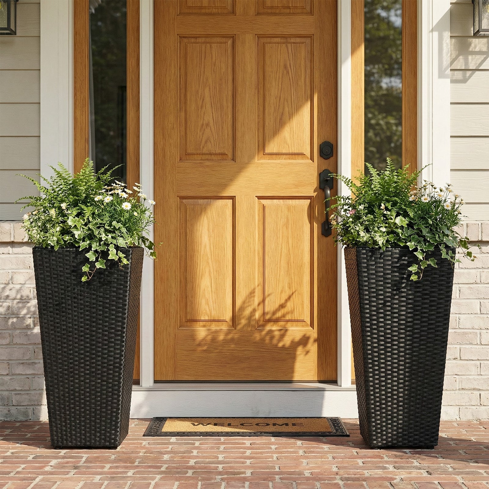 Set of 2 black rattan tall plant pots with detachable liners, greenery and daisies by the door on Tampa Home & Garden Store