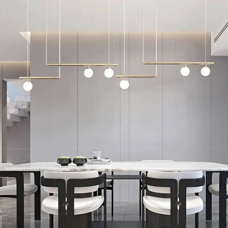 Decorbites linear chandelier with gold bars and white globes over dining table on Tampa Home & Garden Store