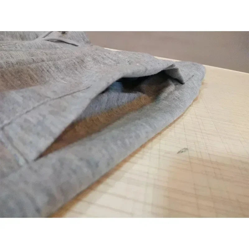 Men's grey baggy joggers folded on a wood table for workout and casual wear on Tampa Home & Garden Store