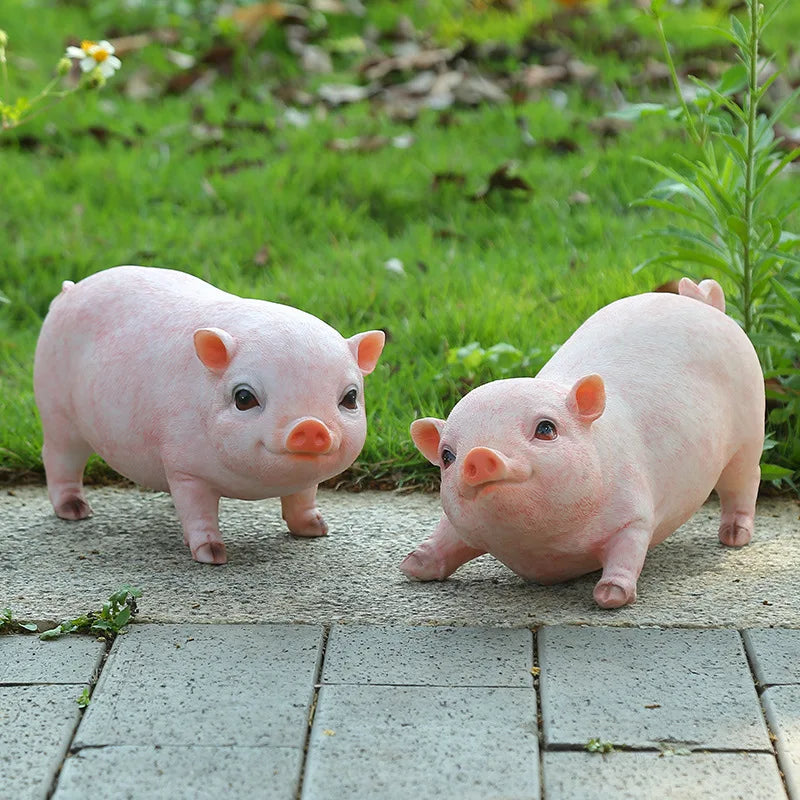 Two pink resin piggy statues for garden decor on Tampa Home & Garden Store