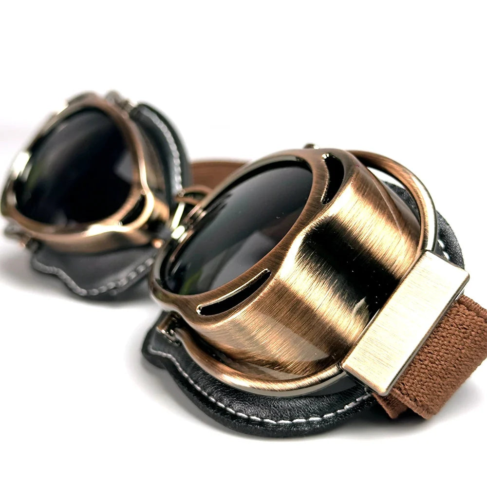 Motorcycle vintage goggles with bronze brushed metal frame, dark lenses, brown strap on Tampa Home & Garden Store