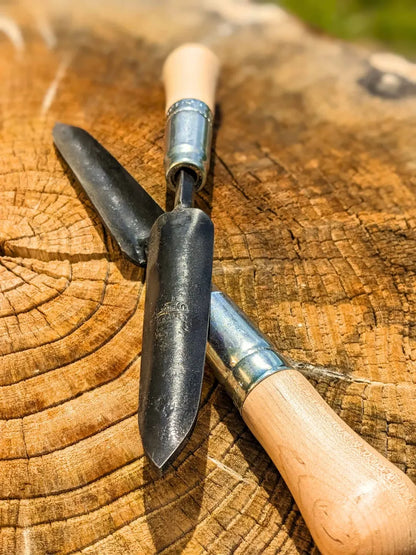 Sharp Shooter Trowel with wooden handle and black blade, two tools total on a tree stump on Tampa Home & Garden Store