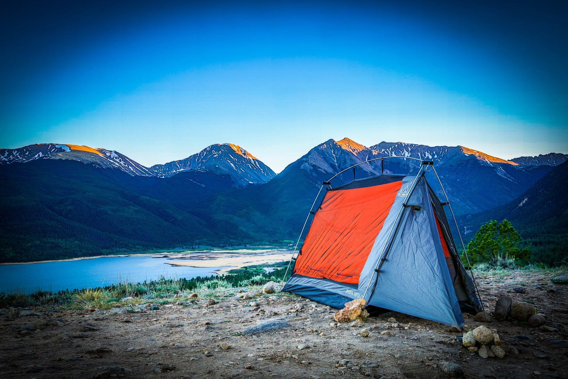 Sky View Solo Tent orange-gray camping tent on rocky lakeside with mountains under blue sky on Tampa Home & Garden Store