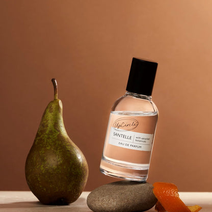 Santelle Eau De Parfum by UpCircle, clear glass bottle with label, pear and orange peel props on Tampa Home & Garden Store