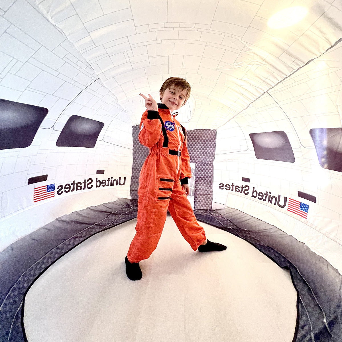 AirFort Space Shuttle Inflatable Play Fort, child in orange spacesuit inside white capsule on Tampa Home & Garden Store