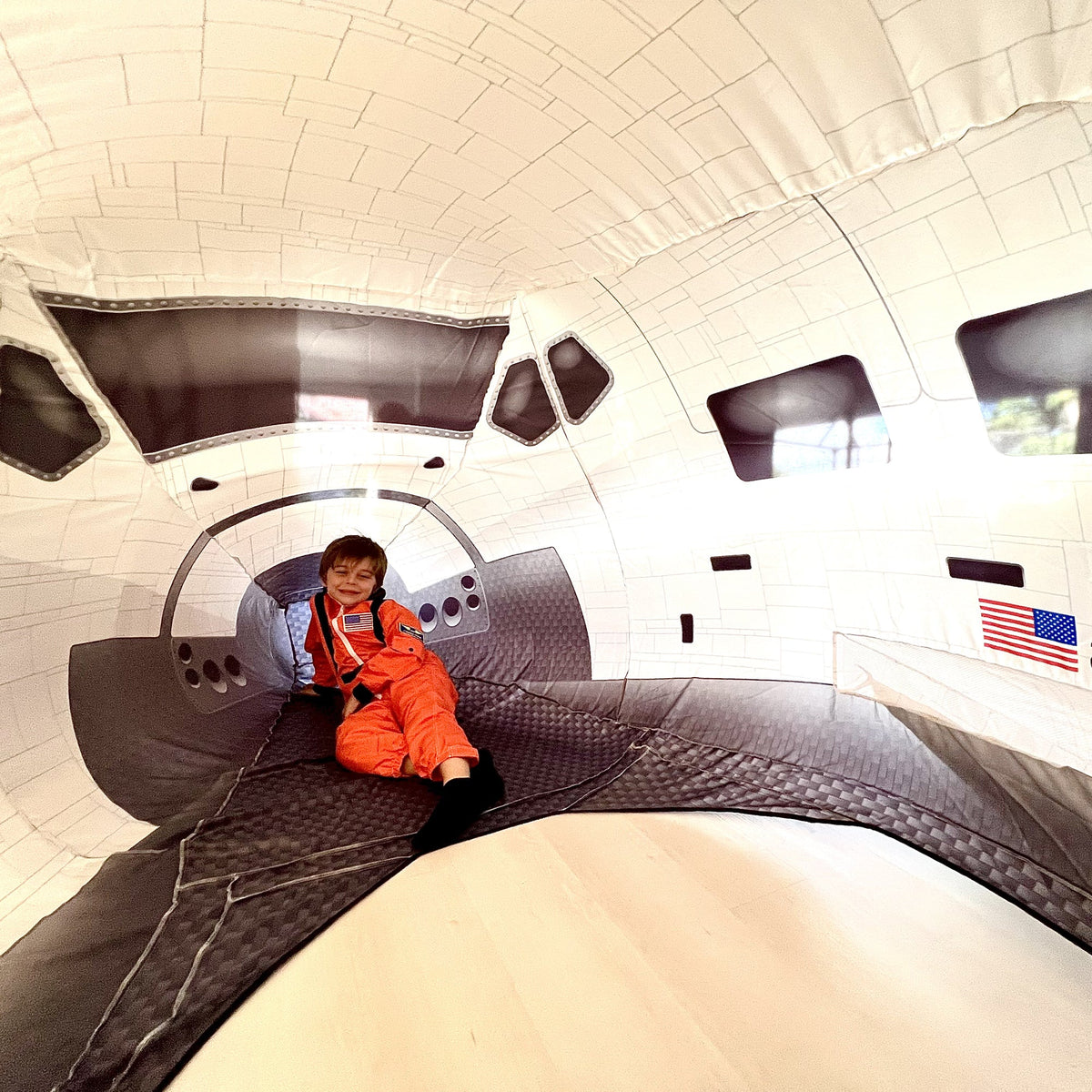 AirFort Space Shuttle inflatable play fort interior with orange suited child on Tampa Home & Garden Store