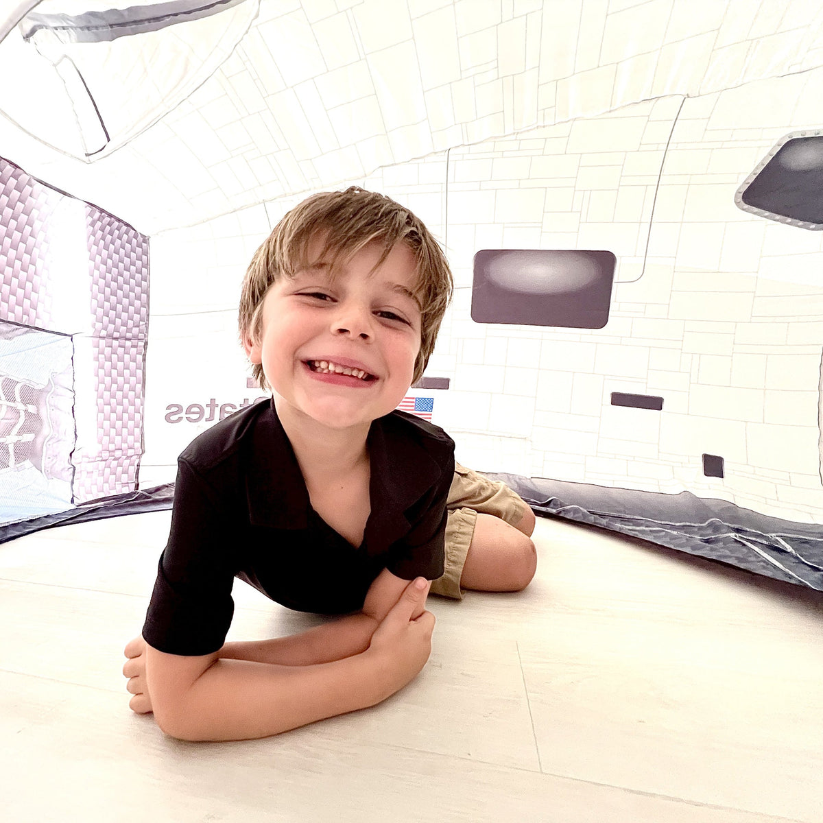 AirFort Space Shuttle Inflatable Play Fort with a smiling child and purple cushions on Tampa Home & Garden Store