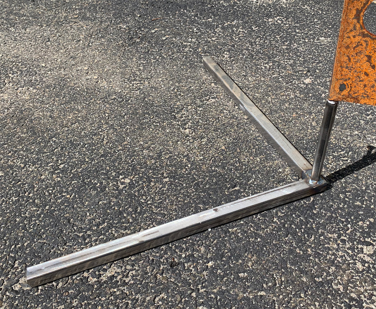 Outdoor metal privacy panel stand with rusted orange panel and steel base on asphalt on Tampa Home & Garden Store