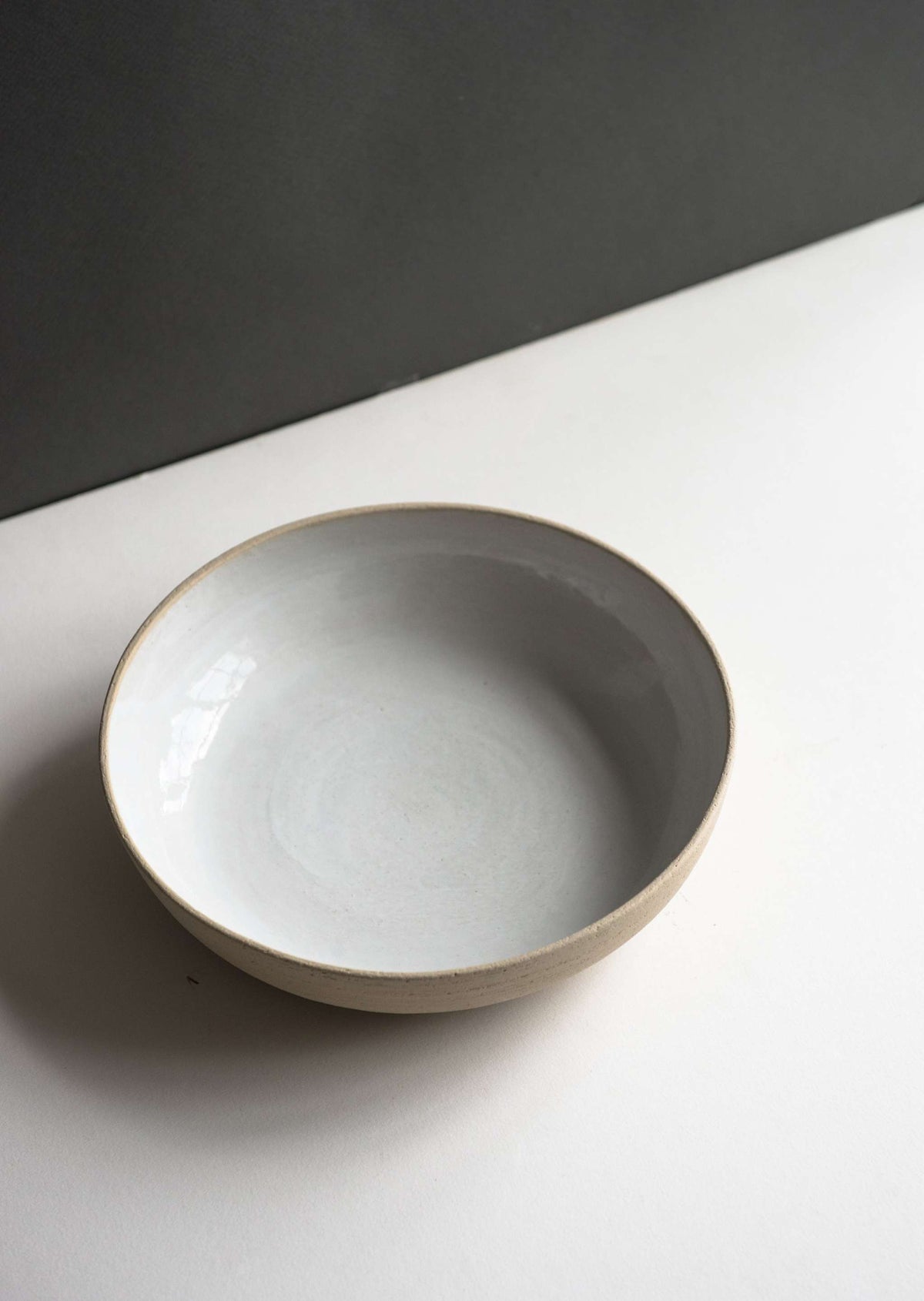 Handmade stoneware pasta bowl with gray interior and beige rim on Tampa Home & Garden Store