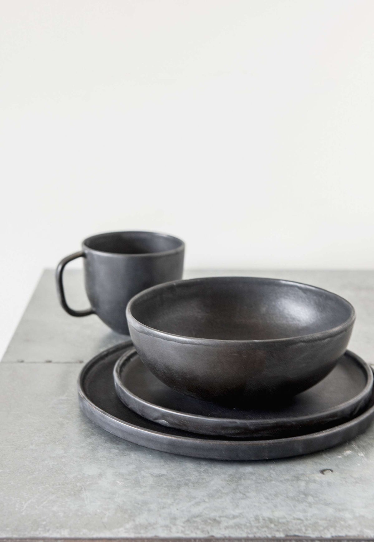 Black matte stoneware coffee mug with two matching bowls on Tampa Home & Garden Store