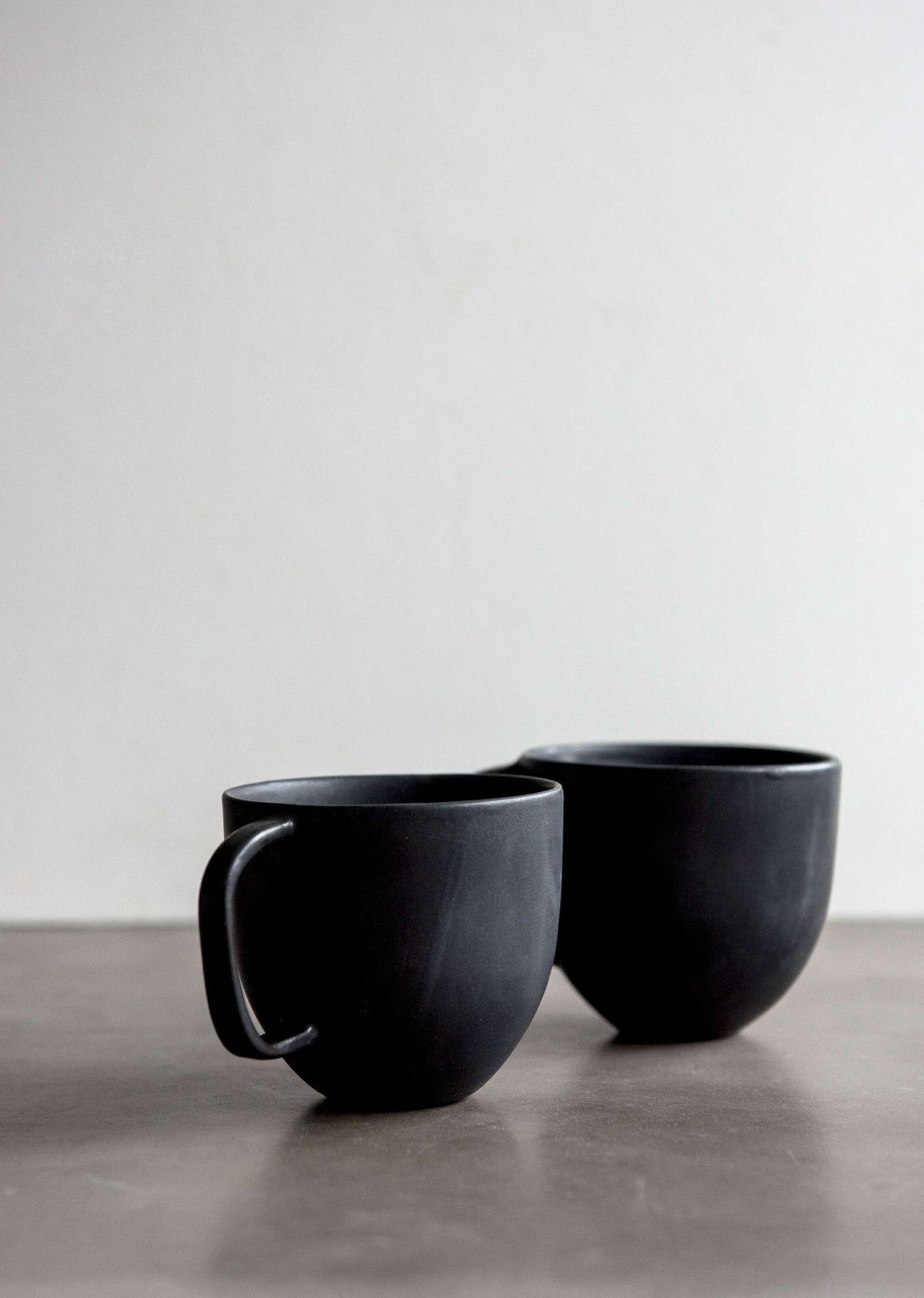 Black matte stoneware coffee mug set of two with curved handles on a neutral surface on Tampa Home & Garden Store