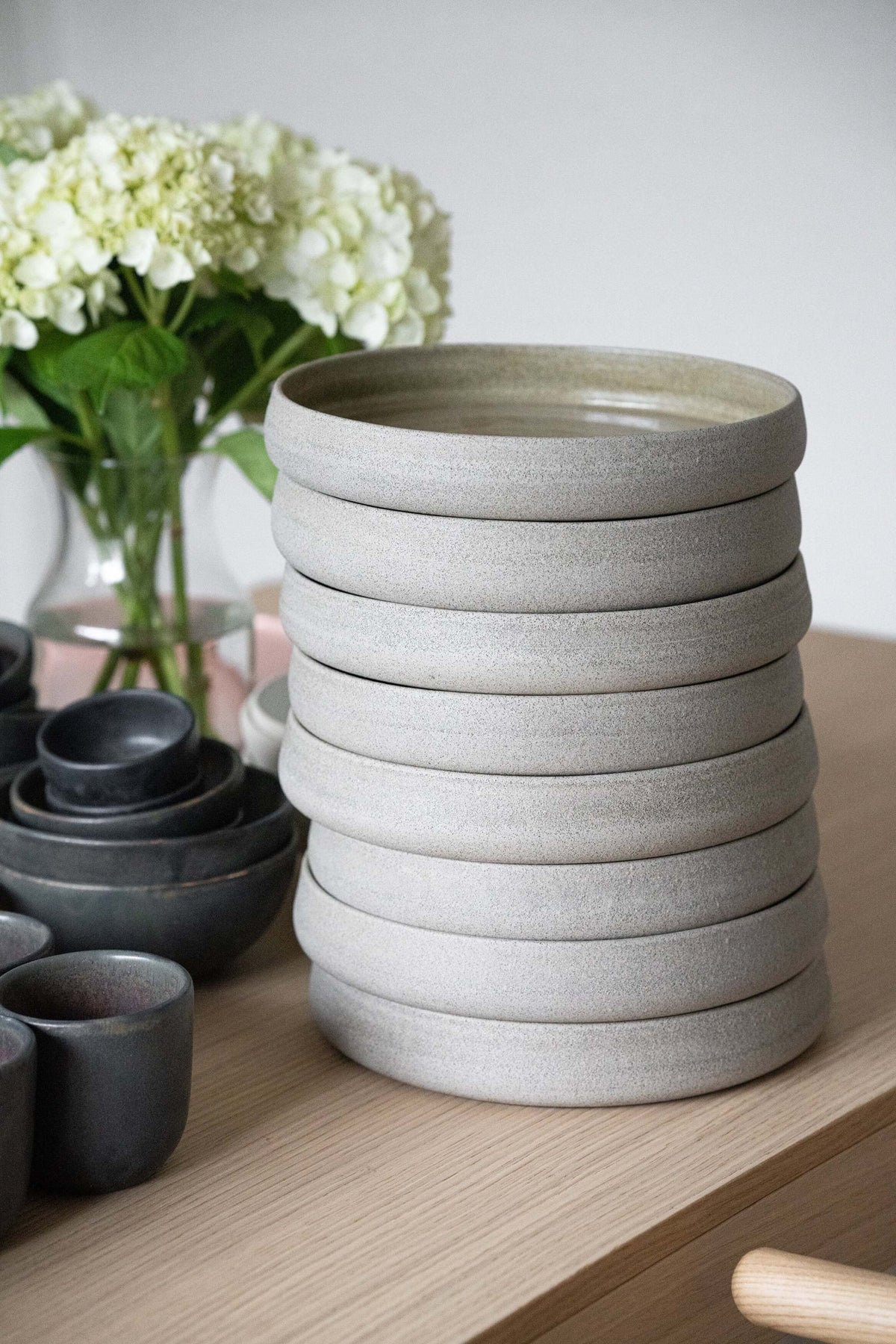 Stoneware dinner plates with high sides in concrete, handmade by CREATING COMFORT; stack of six on Tampa Home & Garden Store