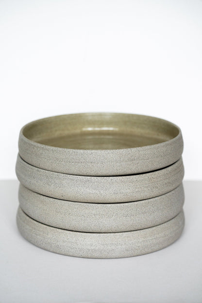 Handmade stoneware dinner plates with high sides in concrete gray, stacked by Creating Comfort on Tampa Home & Garden Store
