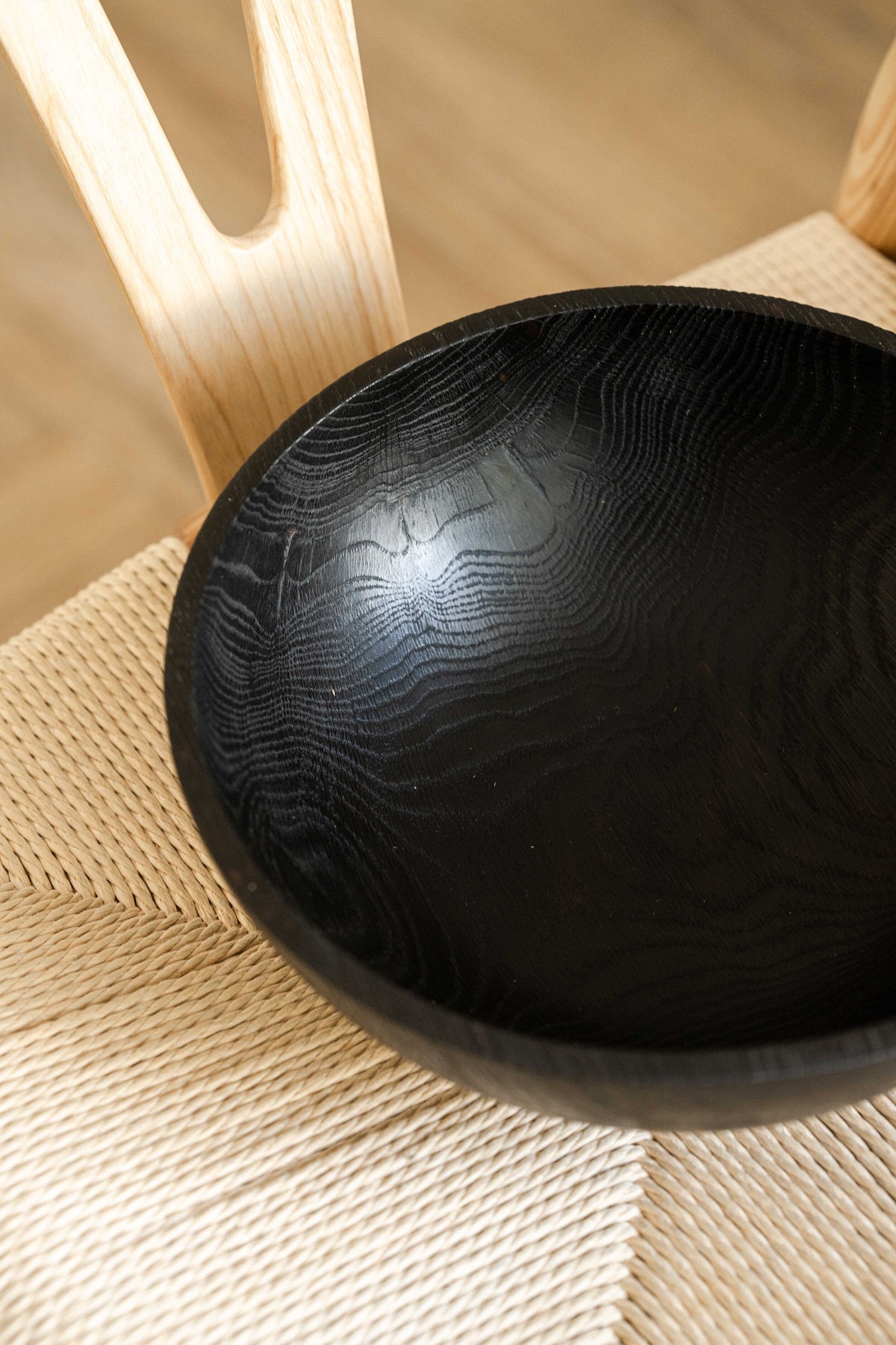Hand-carved large charred wood bowl with black grain texture on woven mat on Tampa Home & Garden Store