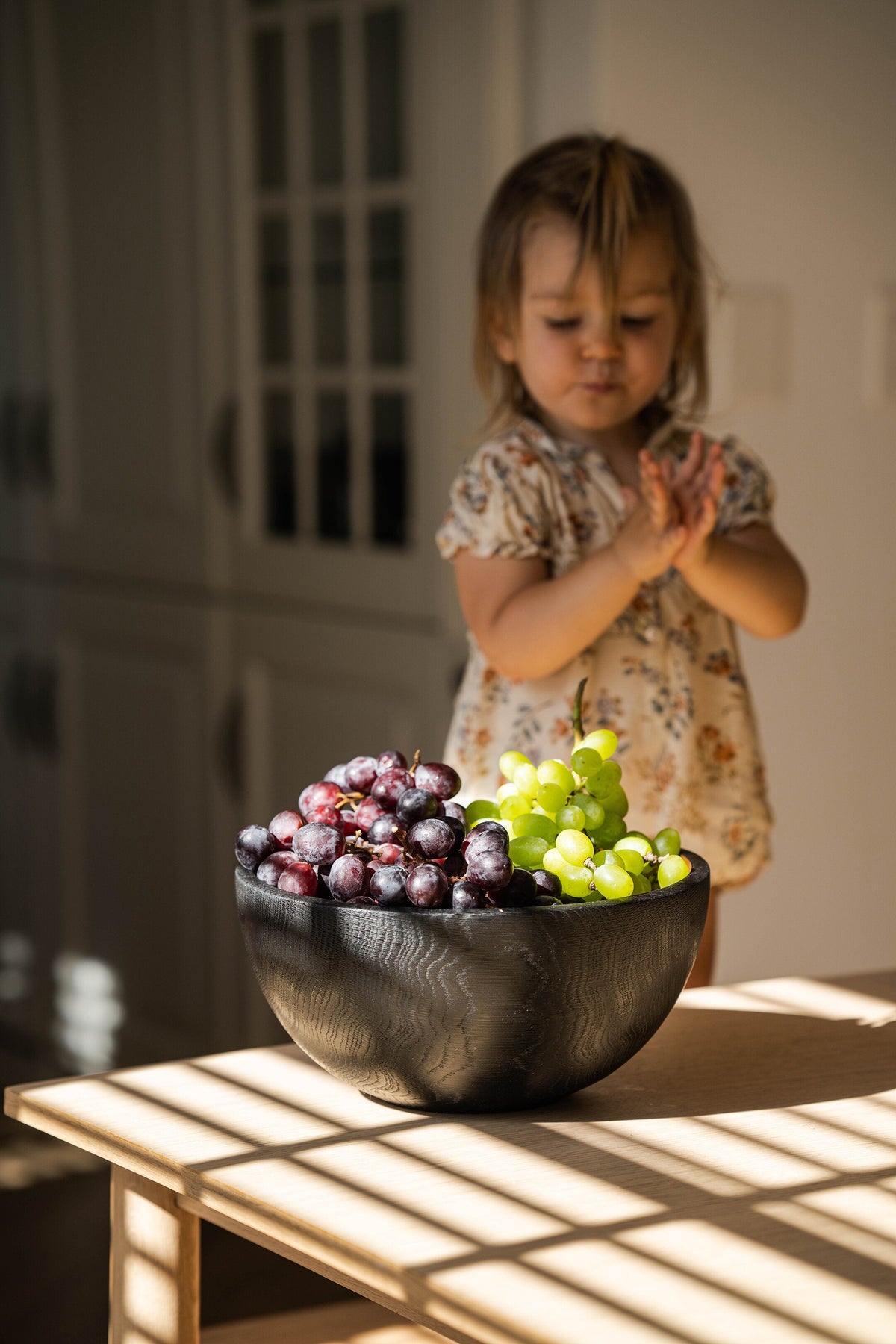 Hand Carved Large Half Charred Wooden Bowl with dark finish holding purple grapes on a wood table on Tampa Home & Garden Store