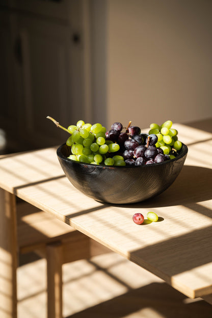 Hand-Carved Charred Wood Bowl with green and purple grapes on sunlit wooden table on Tampa Home & Garden Store