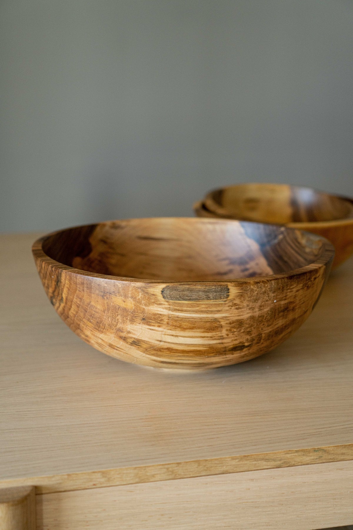 Hand carved walnut wood nesting bowls set; two bowls with rich grain on a light wooden surface on Tampa Home & Garden Store