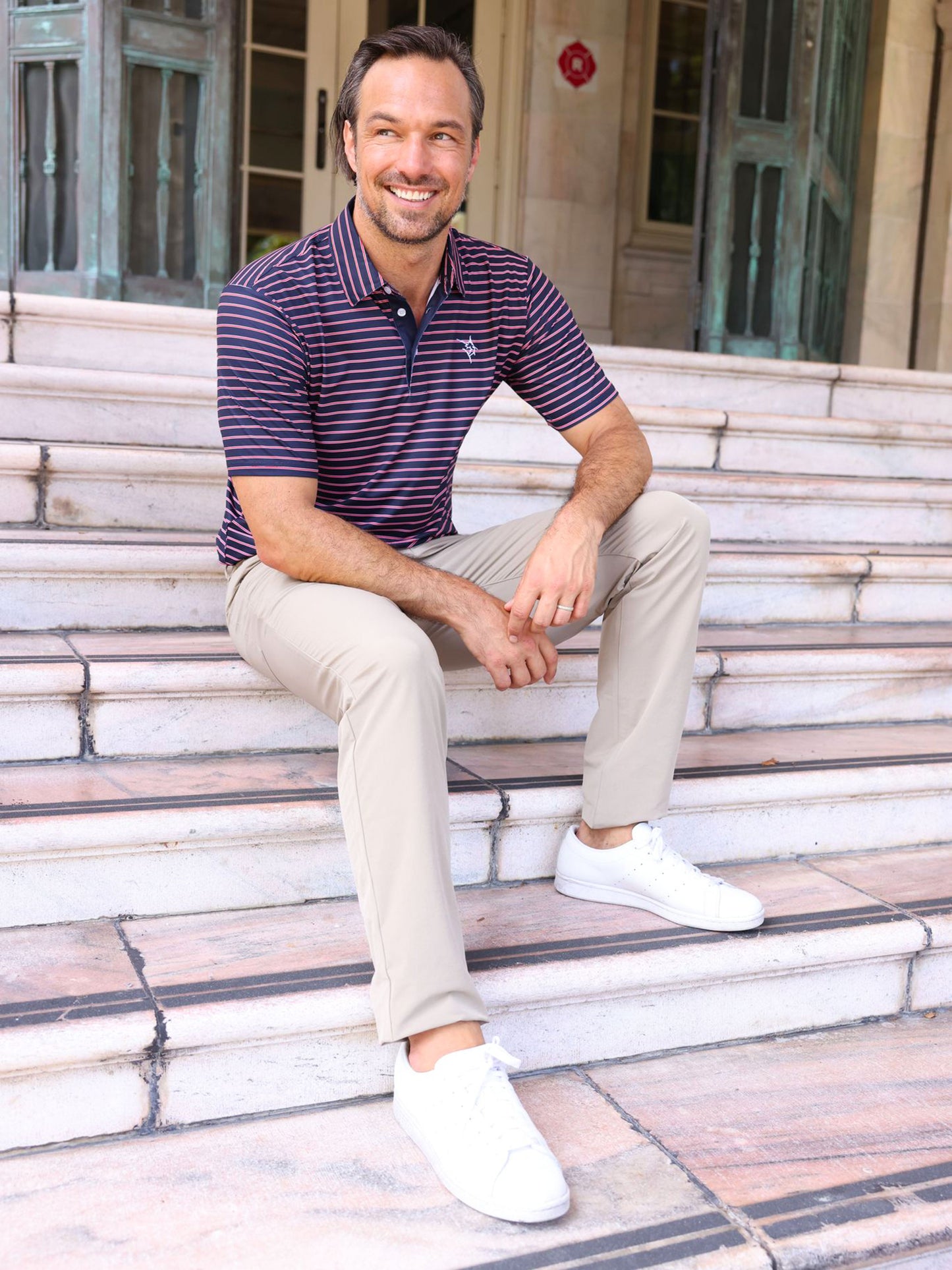 Striper Polo navy with pink stripes by White Water Life worn on a man on outdoor steps on Tampa Home & Garden Store