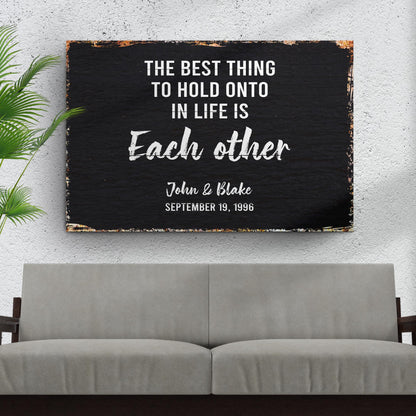 The Best Thing To Hold Onto Life Is Each Other Sign canvas with black background and white text on Tampa Home & Garden Store