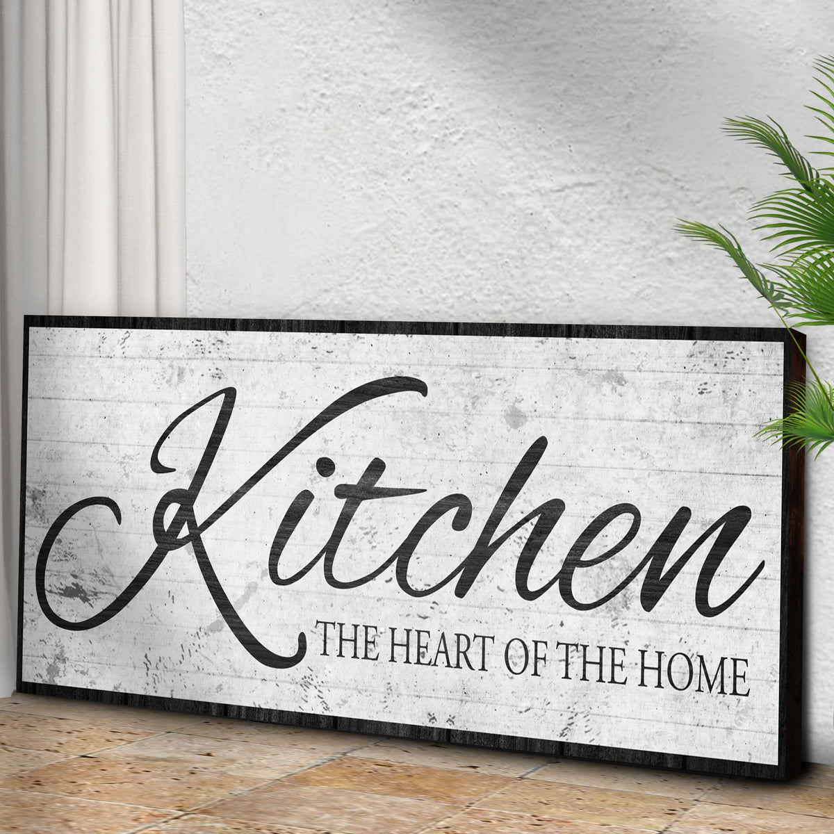 Kitchen Is The Heart Of The Home Sign II canvas by Tailored Canvases on a rustic textured board with a green plant