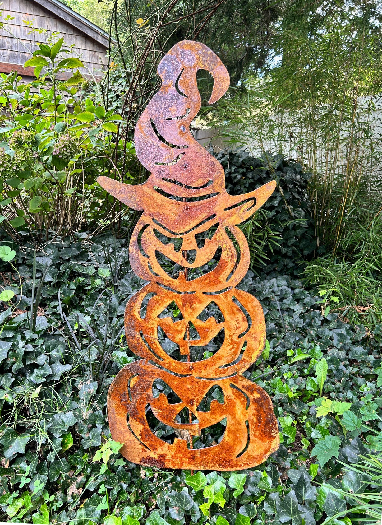 Three stacked pumpkin metal sculpture in rusty orange with cutout faces Rustica Ornamentals decor on Tampa Home & Garden Store