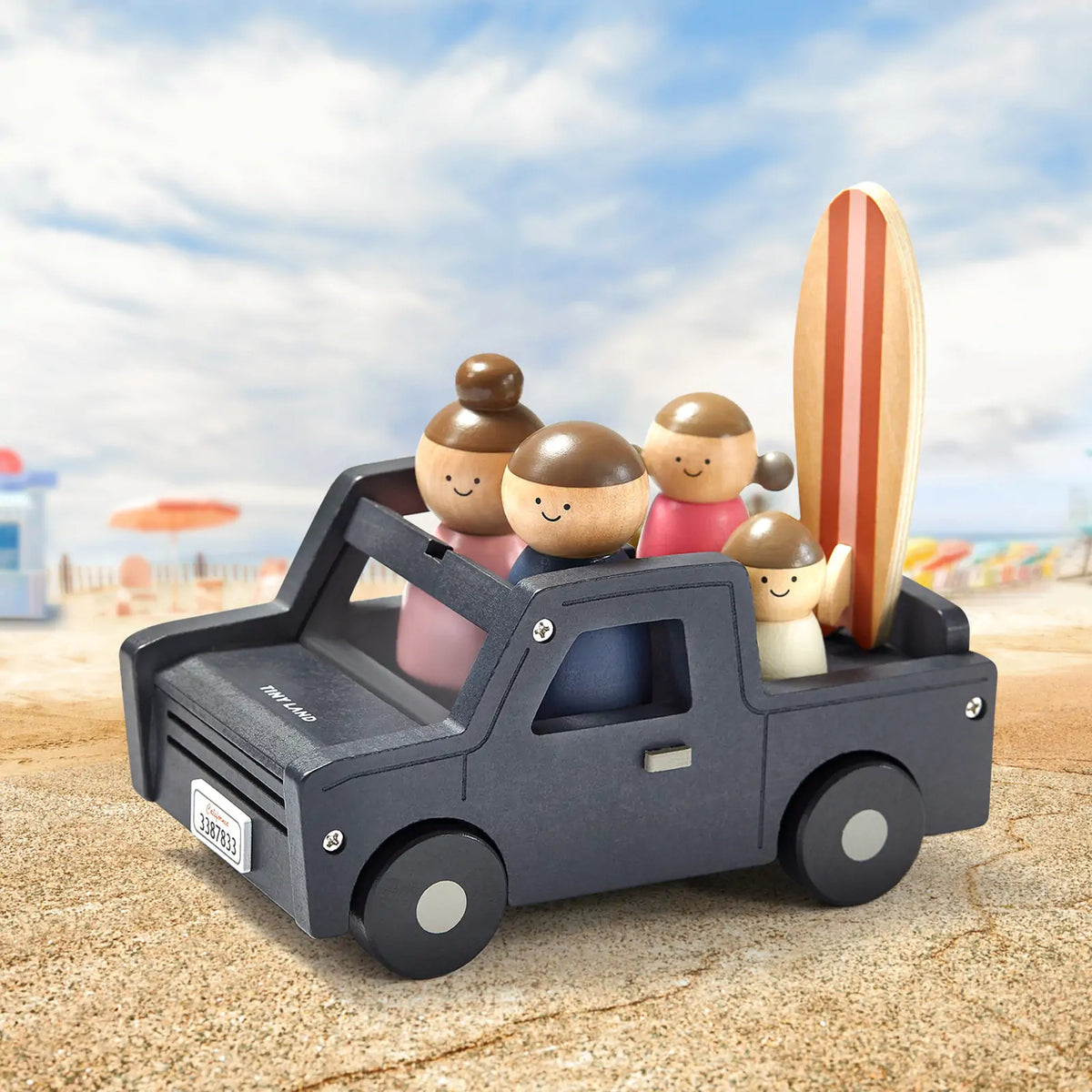 Tiny Land wooden dollhouse garage with smiling dolls in a dark gray vehicle and surfboard on Tampa Home & Garden Store