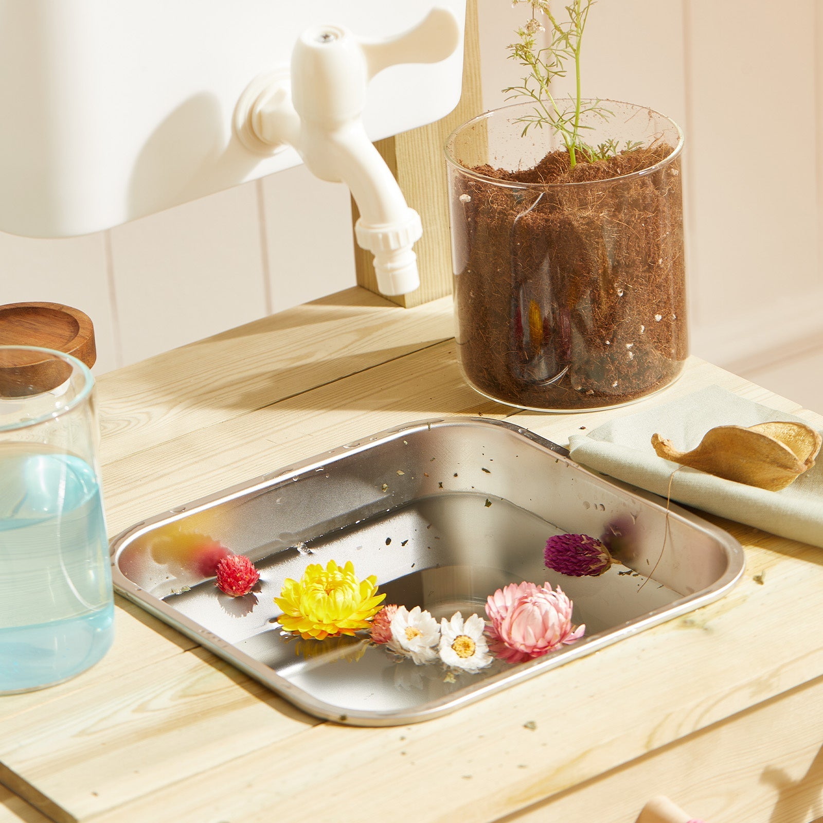 Tiny Land DuoPlay mud kitchen with white faucet and plant in clear pot on wooden counter on Tampa Home & Garden Store