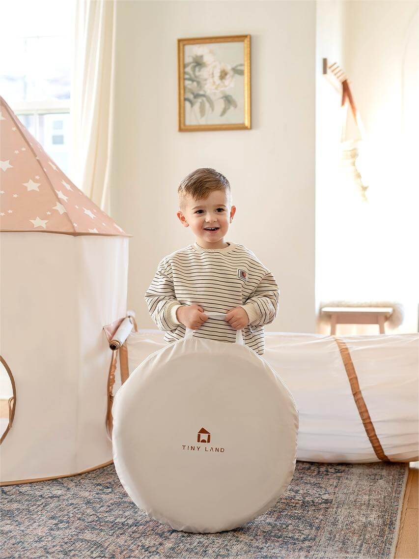 Tiny Land play tunnel round white bag with Tiny Land INC logo; child in pastel playroom on Tampa Home & Garden Store