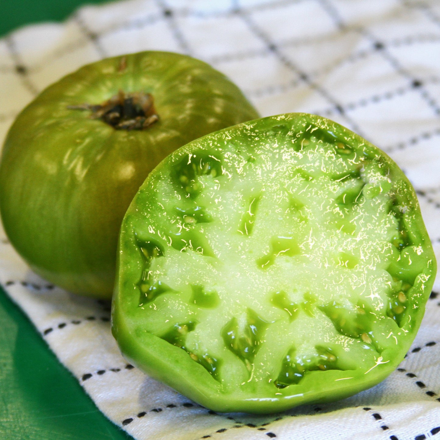 Aunt Ruby's German Green Tomato seeds from Seedtime Store; two glossy green tomatoes on Tampa Home & Garden Store