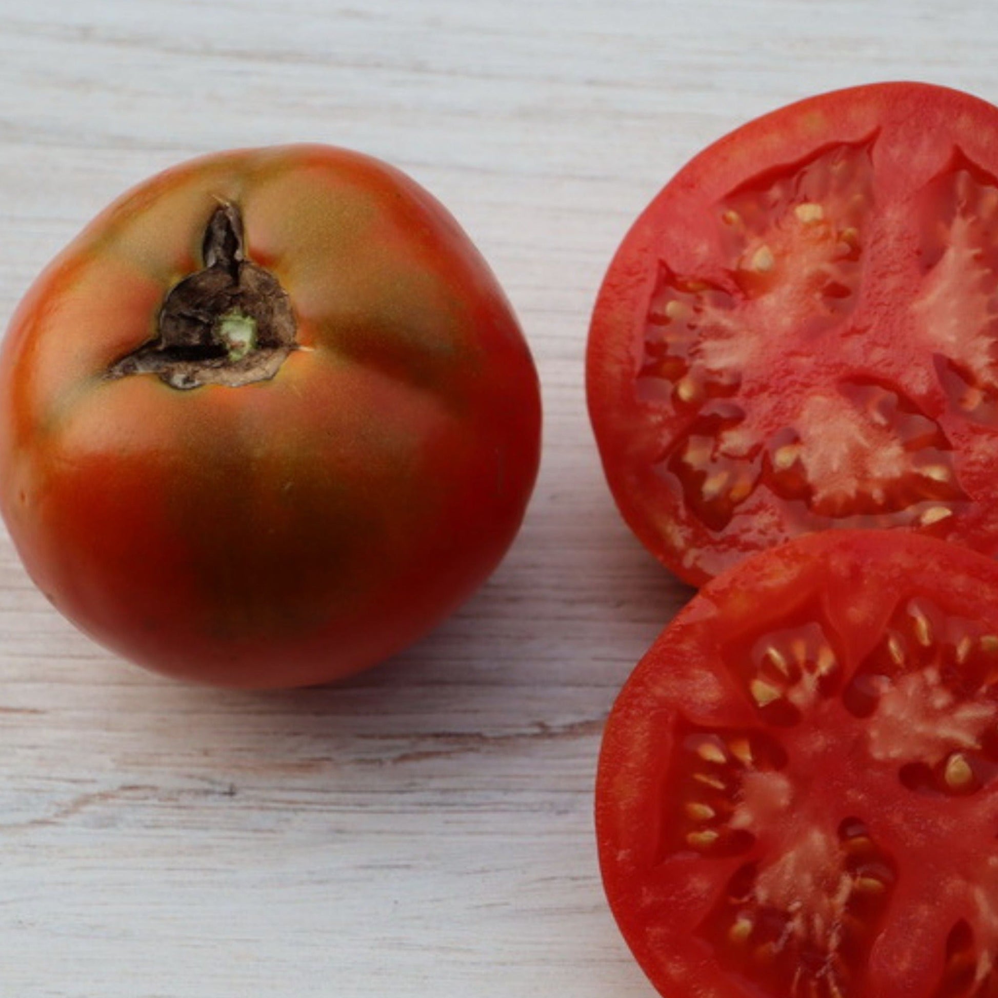 Druzba tomato seeds by Seedtime Store: red tomatoes shown whole and sliced on Tampa Home & Garden Store