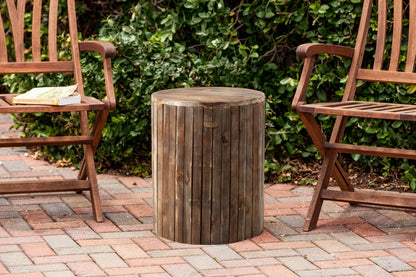 Michael Round Garden Stool round wooden outdoor pouf with vertical slats in weathered brown flanked by two wooden chairs on Tampa Home & Garden Store