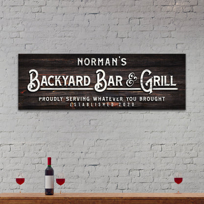 Canvas sign Backyard Bar & Grill on dark wood with lettering on Tampa Home & Garden Store