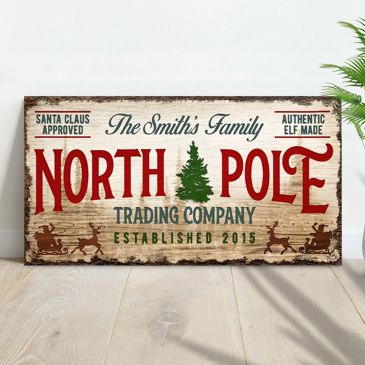 Canvas sign by Tailored Canvases, rustic wood look with red NORTH POLE text and green tree on Tampa Home & Garden Store