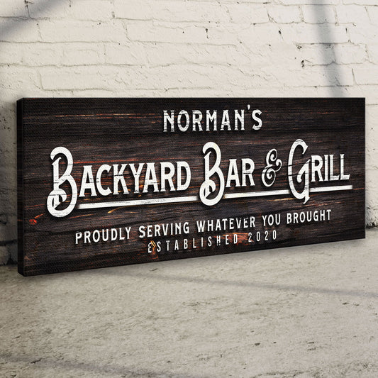 Canvas sign with dark wood grain Norman's Backyard Bar & Grill on white brick wall on Tampa Home & Garden Store