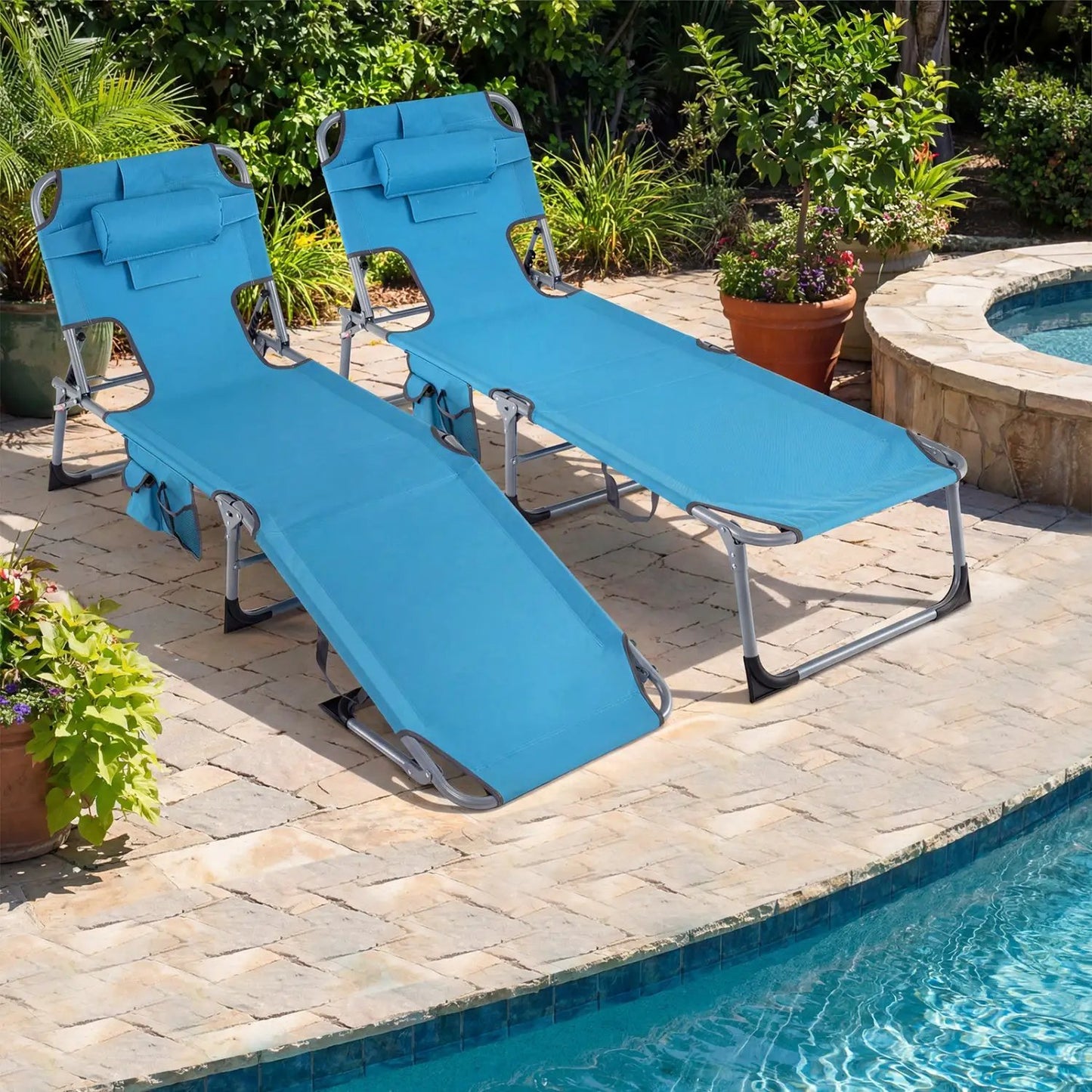 Two blue poolside chaise lounges on a stone patio beside a pool, surrounded by potted plants on Tampa Home & Garden Store