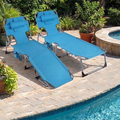 Two blue poolside chaise lounges on a stone patio beside a pool, surrounded by potted plants on Tampa Home & Garden Store