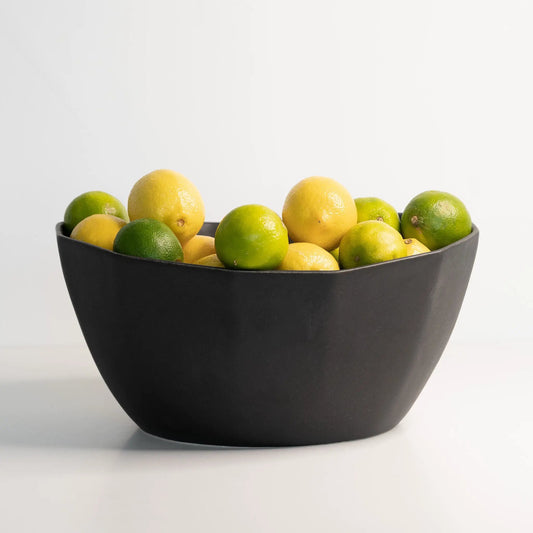 Large black porcelain nesting bowl filled with many lemons and limes on Tampa Home & Garden Store