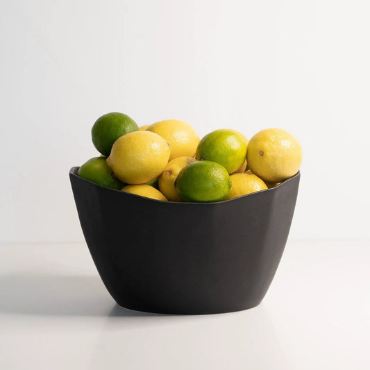 Medium porcelain nesting bowl in black by Ember Collective, filled with lemons and limes on Tampa Home & Garden Store