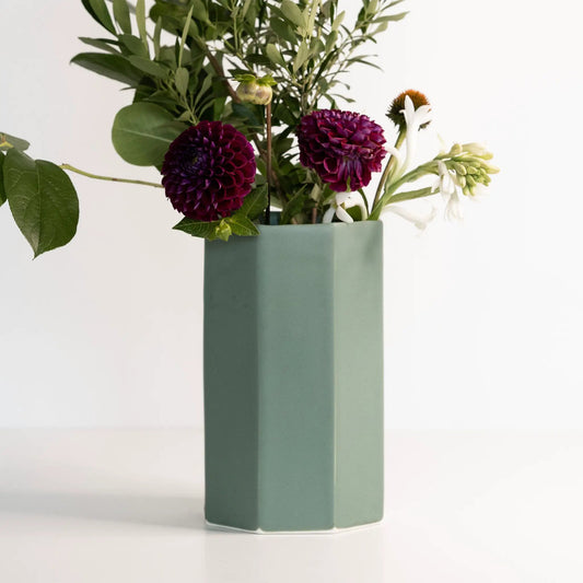 Handmade porcelain bouquet vase in muted teal with a tall faceted silhouette and purple blooms on Tampa Home & Garden Store