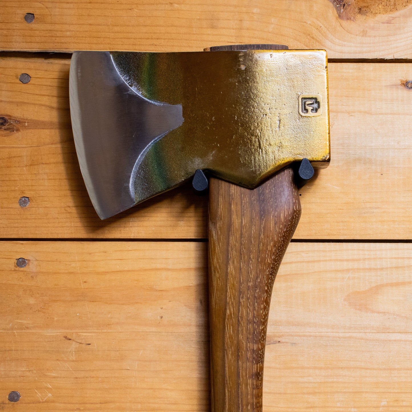Axe Anchors metal axe head with wooden handle on wood surface, small logo on head on Tampa Home & Garden Store