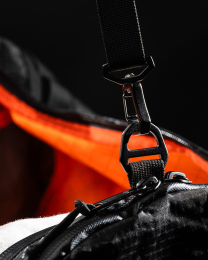 Duffalo duffel bag strap hardware, black nylon webbing with metal clips and orange lining on Tampa Home & Garden Store