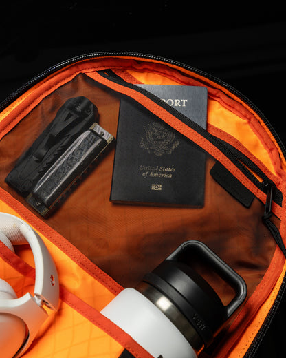 Conceal Pack 21L backpack by The Brown Buffalo with orange interior and passport visible on Tampa Home & Garden Store
