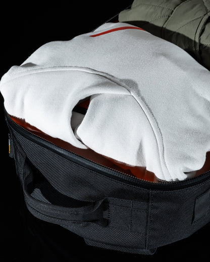 Conceal Pack 21L backpack by The Brown Buffalo, dark denim fabric with a white hoodie inside on Tampa Home & Garden Store