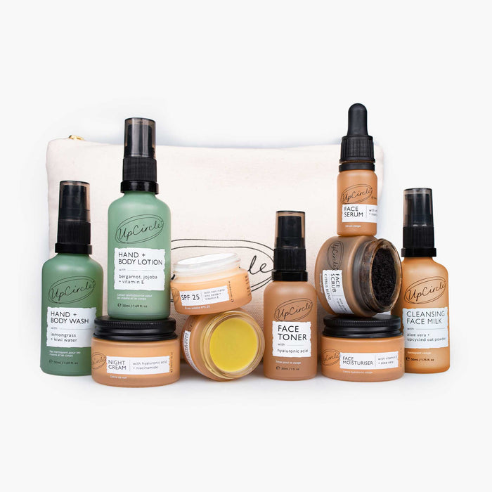 Travel-Size Skincare Bundle by UpCircle with green bottles and tan jars in a gift bag on Tampa Home & Garden Store