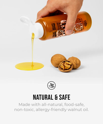 The True Board Premium Walnut Cutting Board Oil 12 oz bottle pours amber oil beside walnuts on Tampa Home & Garden Store