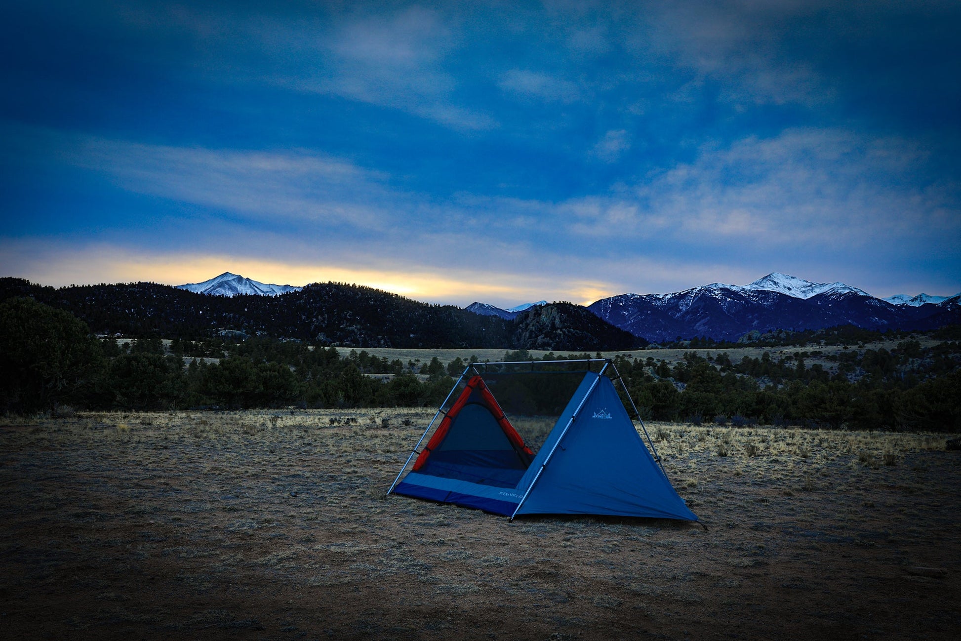 Sky View XL Tent blue tent with red accents set on a grassy field at dusk with mountain backdrop on Tampa Home & Garden Store
